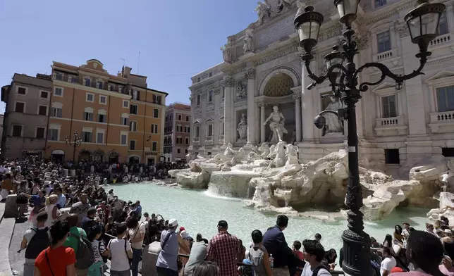 FILE - Tourists admire the Trevi Fountain in Rome, June 7, 2017. (AP Photo/Gregorio Borgia, File)