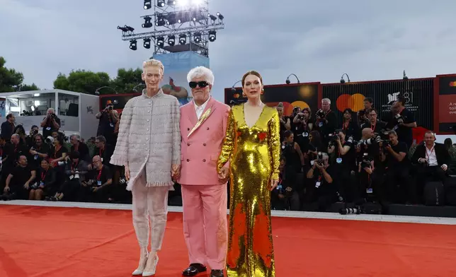 Tilda Swinton, from left, director Pedro Almodovar, and Julianne Moore pose for photographers upon arrival for the premiere of the film 'The Room Next Door' during the 81st edition of the Venice Film Festival in Venice, Italy, on Monday, Sept. 2, 2024. (Photo by Joel C Ryan/Invision/AP)