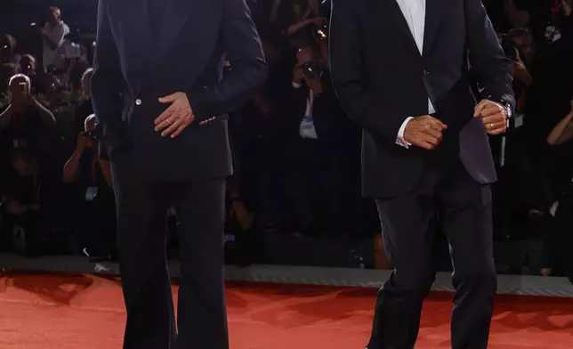 Brad Pitt, left, and George Clooney pose for photographers upon arrival for the premiere of the film 'Wolfs' during the 81st edition of the Venice Film Festival in Venice, Italy, on Sunday, Sept. 1, 2024. (Photo by Joel C Ryan/Invision/AP)