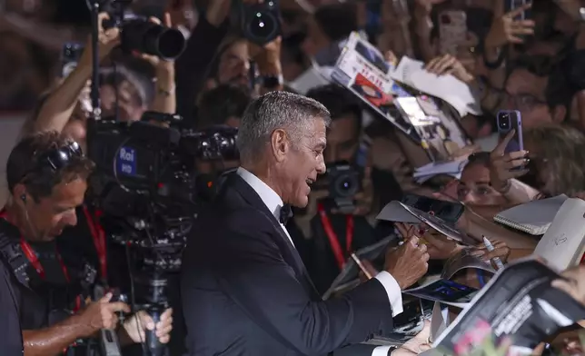 George Clooney signs autographs upon arrival for the premiere of the film 'Wolfs' during the 81st edition of the Venice Film Festival in Venice, Italy, on Sunday, Sept. 1, 2024. (Photo by Vianney Le Caer/Invision/AP)