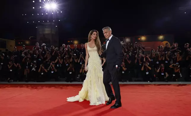 Amal Clooney, left, and George Clooney pose for photographers upon arrival for the premiere of the film 'Wolfs' during the 81st edition of the Venice Film Festival in Venice, Italy, on Sunday, Sept. 1, 2024. (Photo by Joel C Ryan/Invision/AP)