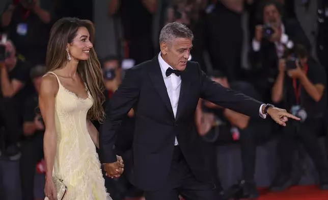 Amal Clooney, left, and George Clooney pose for photographers upon arrival for the premiere of the film 'Wolfs' during the 81st edition of the Venice Film Festival in Venice, Italy, on Sunday, Sept. 1, 2024. (Photo by Vianney Le Caer/Invision/AP)