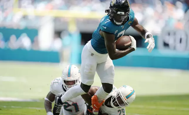 Miami Dolphins cornerback Kendall Fuller (29) grabs Jacksonville Jaguars wide receiver Brian Thomas Jr. (7) during the first half of an NFL football game, Sunday, Sept. 8, 2024, in Miami Gardens, Fla. (AP Photo/Rebecca Blackwell)