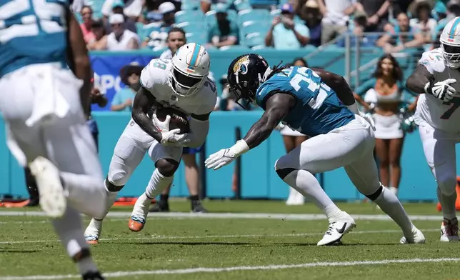 Miami Dolphins running back De'Von Achane (28) runs to score a touchdown during the first half of an NFL football game against the Jacksonville Jaguars, Sunday, Sept. 8, 2024, in Miami Gardens, Fla. (AP Photo/Rebecca Blackwell)