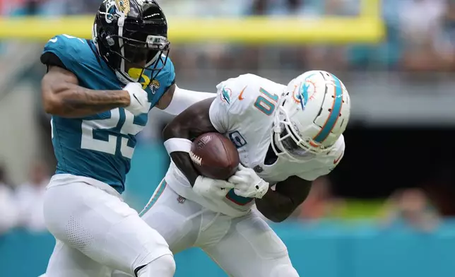 Jacksonville Jaguars cornerback Ronald Darby (25) defends Miami Dolphins wide receiver Tyreek Hill (10) during the first half of an NFL football game, Sunday, Sept. 8, 2024, in Miami Gardens, Fla. (AP Photo/Rebecca Blackwell)