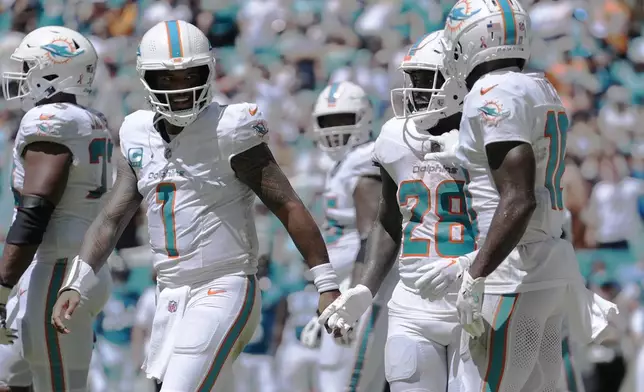 Miami Dolphins quarterback Tua Tagovailoa (1) celebrates a touchdown by running back De'Von Achane (28) during the first half of an NFL football game against the Jacksonville Jaguars, Sunday, Sept. 8, 2024, in Miami Gardens, Fla. (AP Photo/Rebecca Blackwell)