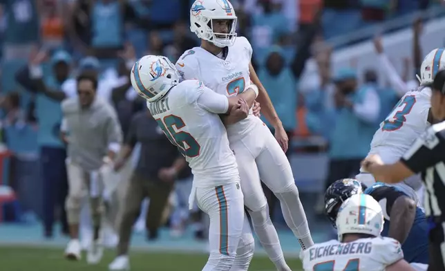 Miami Dolphins punter Jake Bailey (16) lifts place kicker Jason Sanders (7) after Sanders kicked the winning field goal during the second half of an NFL football game against the Jacksonville Jaguars, Sunday, Sept. 8, 2024, in Miami Gardens, Fla. The Dolphins defeated the Jaguars 20-17. (AP Photo/Wilfredo Lee)