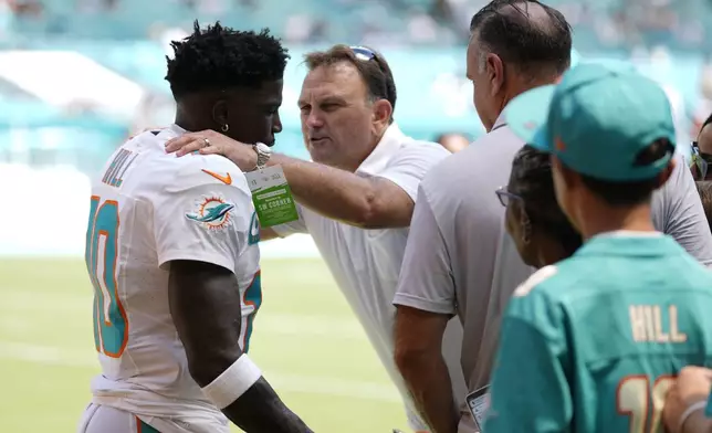 Miami Dolphins wide receiver Tyreek Hill (10) listens to agent Drew Rosenhous before NFL football game against the Jacksonville Jaguars, Sunday, Sept. 8, 2024, in Miami Gardens, Fla. (AP Photo/Rebecca Blackwell)