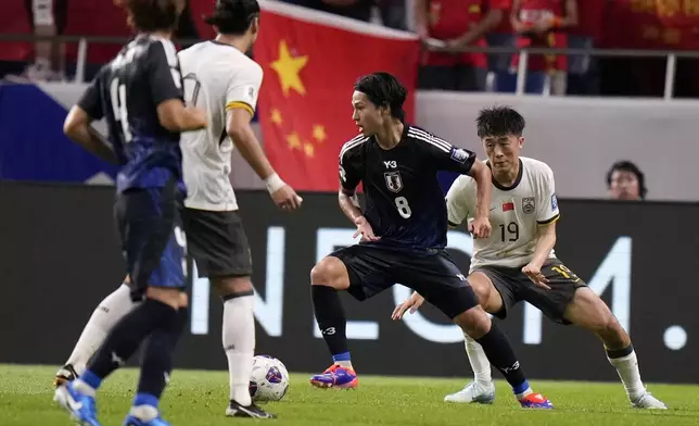 Japan's Takumi Minamino and China's Liu Yangyi compete for the ball during a World Cup and AFC Asian Qualifier between Japan and China at Saitama Stadium 2002 in Saitama, north of Tokyo, Thursday, Sept. 5, 2024.(AP Photo/Shuji Kajiyama)