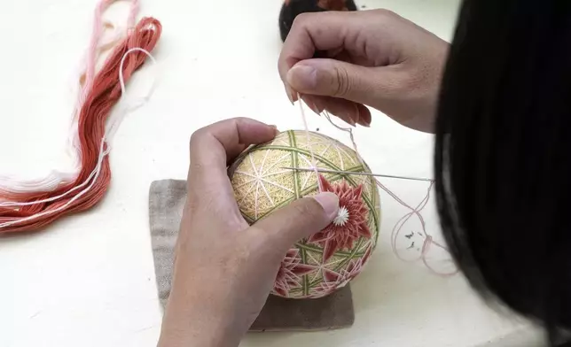 A staff member works on the temari at Sanuki Kagari Temari in Kawaramachi, Kagawa prefecture, Japan, on Sept. 5, 2024. (AP Photo/Ayaka McGill)