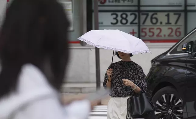 A person walks near an electronic stock board showing Japan's Nikkei index at a securities firm Tuesday, Sept. 24, 2024, in Tokyo. (AP Photo/Eugene Hoshiko)