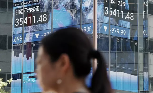 A person walks near an electronic stock board showing Japan's Nikkei index at a securities firm Monday, Sept. 9, 2024, in Tokyo. (AP Photo/Eugene Hoshiko)