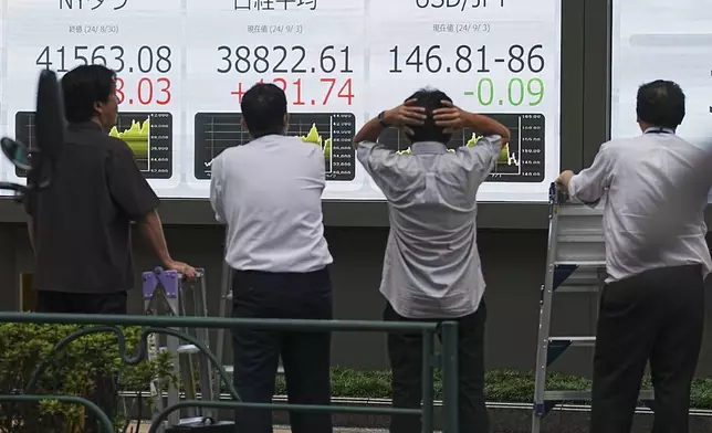 People look at an electronic stock board showing Japan's Nikkei index at a securities firm Tuesday, Sept. 3, 2024, in Tokyo. (AP Photo/Eugene Hoshiko)