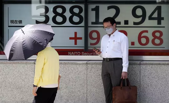 A person stands in front of an electronic stock board showing Japan's Nikkei index at a securities firm Thursday, Sept. 26, 2024, in Tokyo. (AP Photo/Eugene Hoshiko)