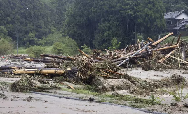 Debris is piled in a river running through Wajima, Japan, Sunday, Sept. 22, 2024, following heavy rain in central Japan's Noto peninsula area, where a devastating earthquake took place on Jan. 1. (Katsunori Nishioka/Kyodo News via AP)