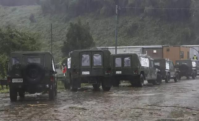 Japan's Self-Defense Forces vehicles deployed to support people in areas affected by severe weather are parked on a mud-covered road in Wajima, Japan, Sunday, Sept. 22, 2024, following heavy rain in central Japan's Noto peninsula area. (Katsunori Nishioka/Kyodo News via AP)