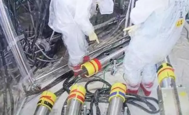 In this photo released by Tokyo Electric Power Company Holdings (TEPCO), monitoring workers rearrange the push-in pipes into the right order, at Fukjushima Daiichi nuclear power plant in Okuma, Fukushima prefecture, northern Japan Saturday, Sept. 7, 2024. (Tokyo Electric Power Company Holdings via AP)