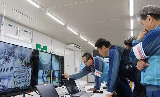 In this photo released by Tokyo Electric Power Company Holdings (TEPCO), TEPCO executives observe plant officials making final procedural checks from an operation room to monitor and remote control an extendable robot, at Fukjushima Daiichi nuclear power plant in Okuma, Fukushima prefecture, northern Japan Monday, Sept. 9, 2024. (Tokyo Electric Power Company Holdings via AP)