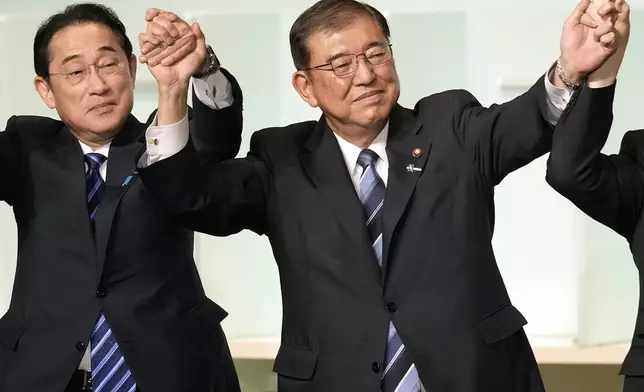 Shigeru Ishiba, right, with Japan's Prime Minister Fumio Kishida, left, and other candidates, celebrates after Ishiba was elected as new head of Japan's ruling Liberal Democratic Party during its leadership election Friday, Sept. 27, 2024, in Tokyo. (AP Photo/Hiro Komae, Pool)