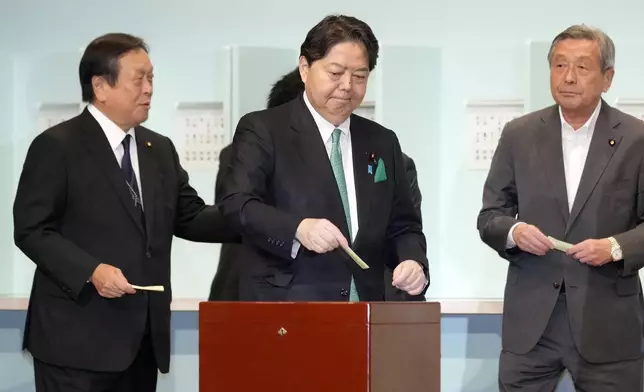 One of candidates, Yoshimasa Hayashi, center, casts his ballot at the Liberal Democratic Party's (LDP) leadership election Friday, Sept. 27, 2024, in Tokyo. (AP Photo/Hiro Komae, Pool)