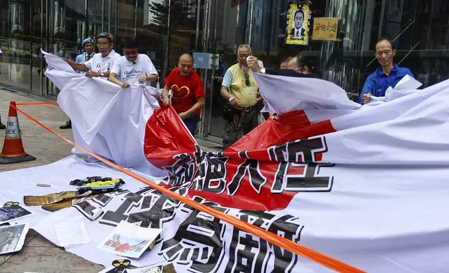 FILE - Protesters tear up a giant Japanese flag with the words "Inhumane, Global Enemy" during a protest against the discharge of treated Fukushima radioactive wastewater, outside the Japan general-consulate in Hong Kong, on Aug. 24, 2023. (AP Photo/Daniel Ceng, File)