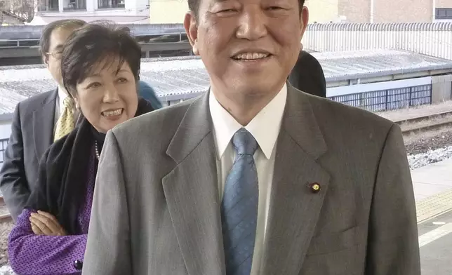 Minister in charge of regional issues Shigeru Ishiba, wearing a JR railway company's cap, smiles at an event by ruling LDP members at Kamakura station in Kamakura, south of Tokyo, December, 2014. (Kyodo News via AP)