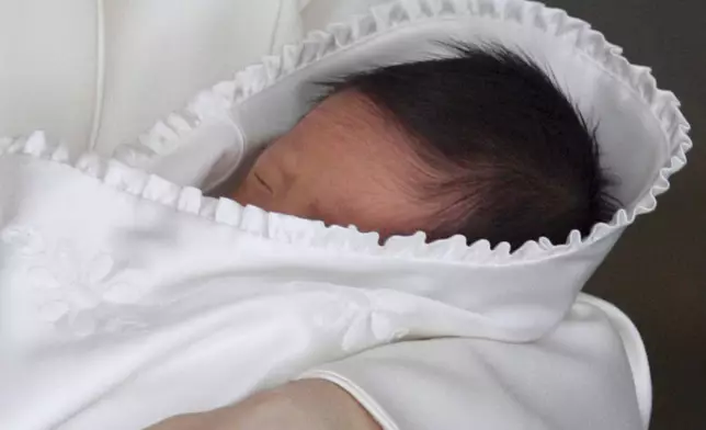 FILE - Japan's newborn Prince Hisahito sleeps in the arms of his mother Crown Princess Kiko as he leaves a Tokyo hospital Sept. 15, 2006. (AP Photo/Itsuo Inouye, Pool, File)