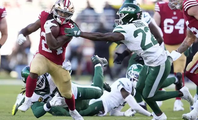 San Francisco 49ers running back Jordan Mason, left, runs against New York Jets safety Tony Adams (22) during the first half of an NFL football game in Santa Clara, Calif., Monday, Sept. 9, 2024. (AP Photo/Godofredo A. Vásquez)