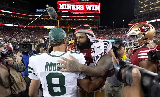 New York Jets quarterback Aaron Rodgers (8) talks with San Francisco 49ers offensive tackle Trent Williams, center right, after an NFL football game in Santa Clara, Calif., Monday, Sept. 9, 2024. (AP Photo/Godofredo A. Vásquez)