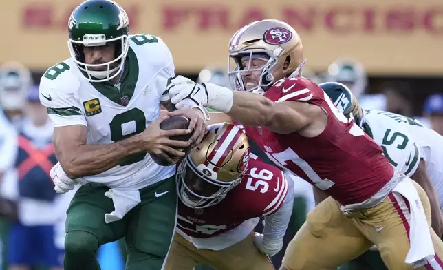 New York Jets quarterback Aaron Rodgers tries to scramble from San Francisco 49ers defensive end Leonard Floyd (56) and defensive end Nick Bosa, right, before being sacked by Floyd during the first half of an NFL football game in Santa Clara, Calif., Monday, Sept. 9, 2024. (AP Photo/Godofredo A. Vásquez)