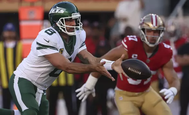 New York Jets quarterback Aaron Rodgers (8) pitches the ball to a running back as San Francisco 49ers defensive end Nick Bosa, right, runs toward the play during the first half of an NFL football game in Santa Clara, Calif., Monday, Sept. 9, 2024. (AP Photo/Jed Jacobsohn)