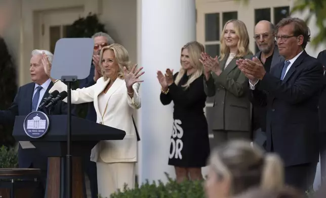 First lady Jill Biden, with actors Martin Sheen, left, Aaron Sorkin, right, and other members of the cast of The West Wing, is applauded as she hosts an event on the Rose Garden at the White House to mark the 25th anniversary of the television series, The West Wing, Friday, Sept. 20, 2024, in Washington. (AP Photo/Manuel Balce Ceneta)