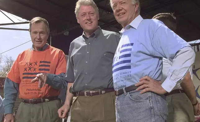 FILE - Former Presidents George Bush, left, and Jimmy Carter, right, stand with President Clinton during a kick-off rally for the President's volunteer summit at Marcus Foster Stadium in Philadelphia, PA., April 27, 1997. (AP Photo/Greg Gibson, File)