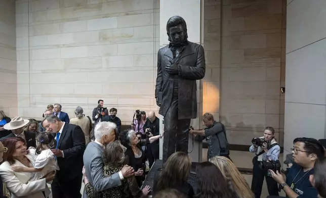 Joanne Cash, center left, sister of Johnny Cash, touches his statue accompanied by his daughter Rosanne Cash, far left, at the unveiling of a bronze statue of singer Johnny Cash, created by Little Rock sculptor Kevin Kresse, in Emancipation Hall at the Capitol in Washington, Tuesday, Sept. 24, 2024. (AP Photo/Ben Curtis)