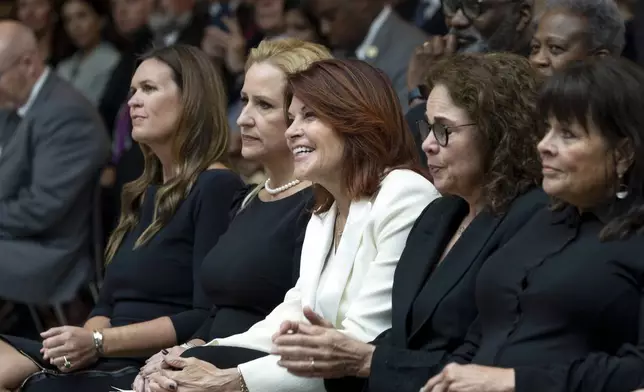 From left to right, Arkansas Gov. Sarah Huckabee Sanders, Arkansas Lt. Gov. Leslie Rutledge, and daughters of Johnny Cash Rosanne Cash, Tara Cash Schwoebel, and Kathy Cash, listen to a band play his song "I walk the Line" at the unveiling of a bronze statue of singer Johnny Cash, created by Little Rock sculptor Kevin Kresse, in Emancipation Hall at the Capitol in Washington, Tuesday, Sept. 24, 2024. (AP Photo/Ben Curtis)