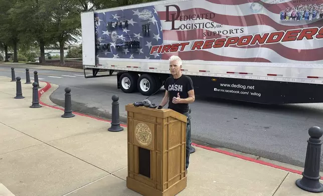 Artist Kevin Kresse, who sculpted a statue of Johnny Cash destined for the U.S. Capitol, speaks in front of a tractor trailer parked outside the Arkansas Capitol in Little Rock, Ark., Thursday, Sept. 5, 2024. (AP Photo/Andrew DeMillo)