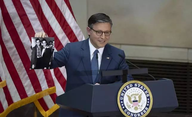 House Speaker Mike Johnson, R-La., holds up a photograph of Elvis Presley and Johnny Cash, at the unveiling of a bronze statue of singer Johnny Cash, created by Little Rock sculptor Kevin Kresse, in Emancipation Hall at the Capitol in Washington, Tuesday, Sept. 24, 2024. (AP Photo/Ben Curtis)