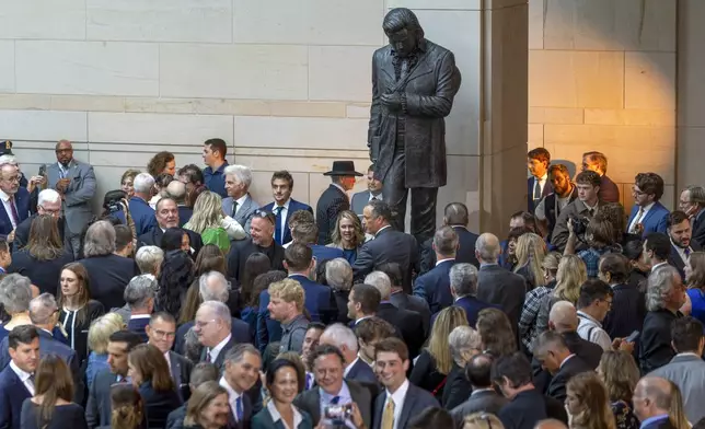 People gather around the statue after the unveiling of a bronze statue of singer Johnny Cash in Emancipation Hall at the Capitol in Washington, Tuesday, Sept. 24, 2024. (AP Photo/Ben Curtis)