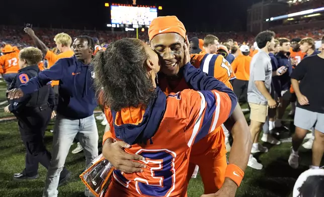 Illinois wide receiver Pat Bryant is kissed by his mom after the team's 23-17 upset win over Kansas after an NCAA college football game Saturday, Sept. 7, 2024, in Champaign, Ill. (AP Photo/Charles Rex Arbogast)