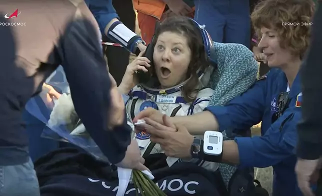 In this photo taken from video released by Roscosmos space corporation, the NASA astronaut Tracy Dyson is gifted with flowers shortly after the landing of the Russian Soyuz MS-25 space capsule carrying the NASA astronaut Tracy Dyson and the Roscosmos cosmonauts Oleg Kononenko and Nikolai Chub, south-east of the Kazakh town of Zhezkazgan, Kazakhstan, Monday, Sept. 23, 2024. (Roscosmos space corporation via AP)