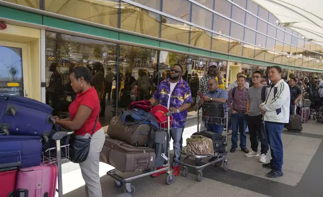 Stranded passengers wait for their delayed flights out of JKIA airport after flights were grounded following workers’ protesting a planned deal between the government and a foreign investor, in Nairobi, Kenya, Wednesday, Sept. 11, 2024. (AP Photo/Brian Inganga)