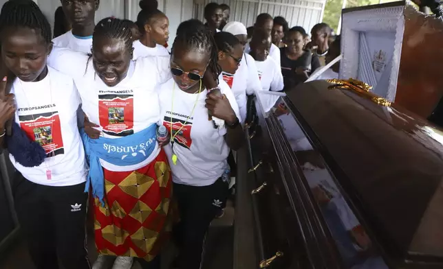 Relatives try to comfort a woman crying after viewing the body of Ugandan Olympic athlete Rebecca Cheptegei at Moi Teaching and Referral Hospital morgue in the western city of Eldoret, in Rift Valley, Kenya Friday, Sept. 13, 2024. (AP Photo/Andrew Kasuku)