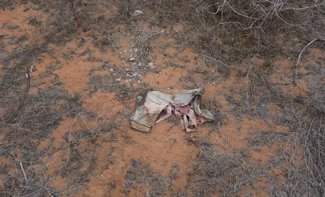 A piece of clothing lies in the bush near the forest where dozens of bodies were found in shallow graves in the village of Shakahola, near the coastal city of Malindi, in southern Kenya, on Thursday, Sept. 5, 2024. (AP Photo/Brian Inganga)