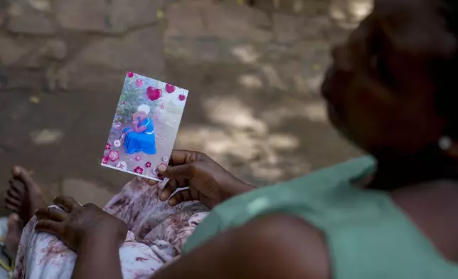 Priscillar Riziki holds a photo of her daughter, Lorine Menza, a member of the Good News International Church cult now presumed dead, at her home in the coastal city of Malindi, in southern Kenya, on Saturday, Sept. 7, 2024. (AP Photo/Brian Inganga)