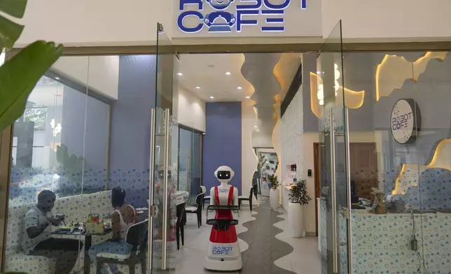 Robotic waiter serves customers at a Robot Cafe in Nairobi, Kenya Thursday, Aug. 29, 2024. The three robots, christened Claire, R24 and Nadia, are not programmed to have a full conversation with customers, but they can say "Your order is ready, Welcome" then people have to press an exit button after picking up their food from the tray. (AP Photo/Brian Inganga)