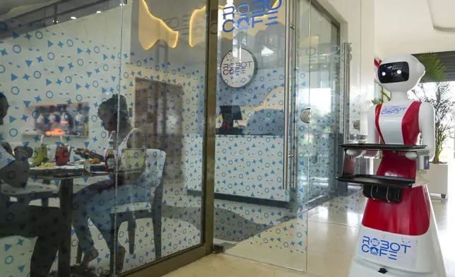 Robotic waiter serves customers at a Robot Cafe in Nairobi, Kenya Thursday, Aug. 29, 2024. The three robots, christened Claire, R24 and Nadia, are not programmed to have a full conversation with customers, but they can say "Your order is ready, Welcome" then people have to press an exit button after picking up their food from the tray. (AP Photo/Brian Inganga)