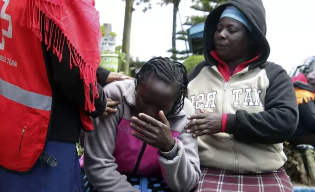 Kenya Red Cross personnel and relatives try to comfort a woman reacting near a burned-out dormitory, following a fire at the Hillside Endarasha Primary in Nyeri, Kenya Friday, Sep. 6, 2024. (AP Photo)