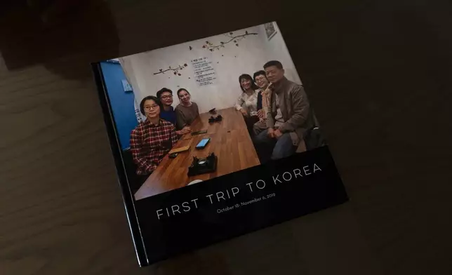 A photo book sits in the home of Han Tae-soon in Anyang, South Korea, on Saturday, June 1, 2024. Han's daughter, Laurie Bender, third from right sitting next to Han, made her the album to celebrate their reunion. Bender was approached by a strange woman while playing in the front yard in Korea in 1975. She remembers the woman saying that Bender's family didn't want her anymore because her mother had another baby. She went with the woman and felt so sad she thought she might die. (AP Photo/Jae C. Hong)