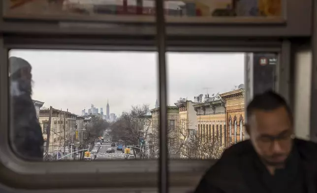 Robert Calabretta rides the subway Thursday, Feb. 15, 2024, in New York, with the Empire State Building in the background. (AP Photo/David Goldman)