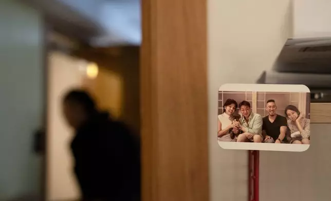 A photo magnet of Robert Calabretta, second from right, when he reunited with his biological mother, left, and siblings, decorates his apartment, Friday, Feb. 16, 2024, in New York. He prefers his new name now: Hanil Lee. (AP Photo/David Goldman)